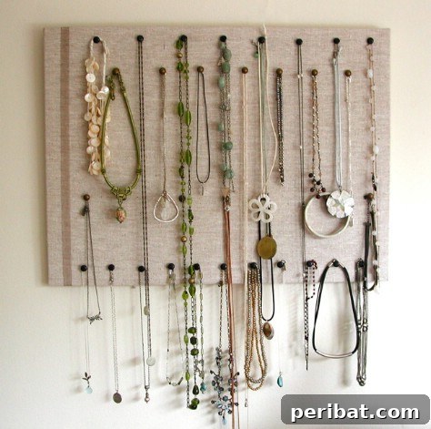 85 Genius Home Organization and Storage Hacks for Every Space 40 Fabric-covered corkboard displaying necklaces and earrings with pins