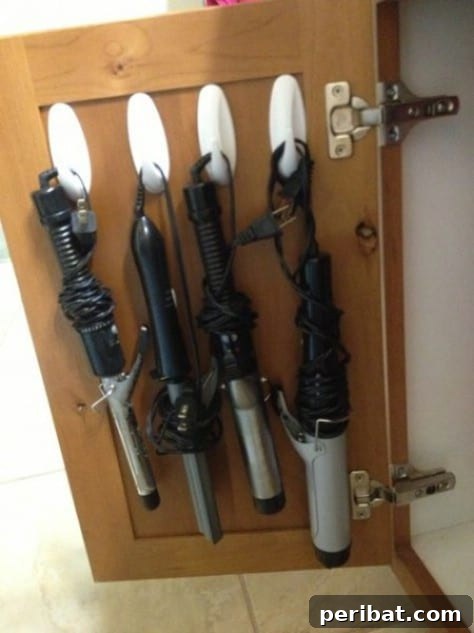 85 Genius Home Organization and Storage Hacks for Every Space 49 Hooks attached inside a cabinet door to hang curling irons