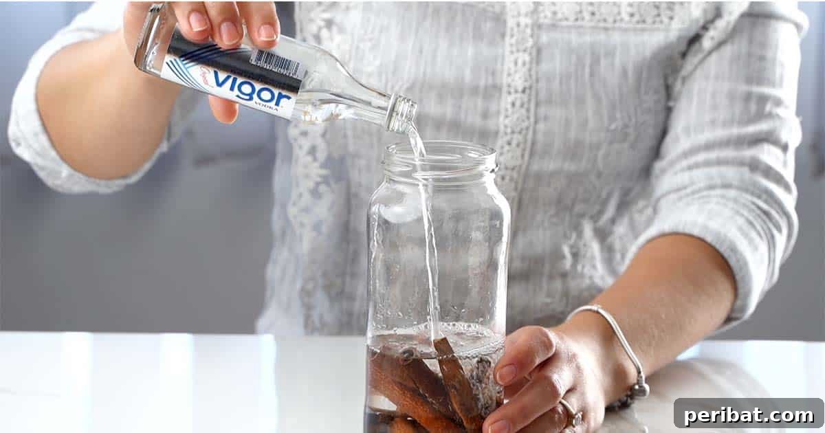 Mastering Homemade Cinnamon Extract 6 Pouring vodka over cinnamon sticks in a jar, ensuring full submersion for the extraction process.