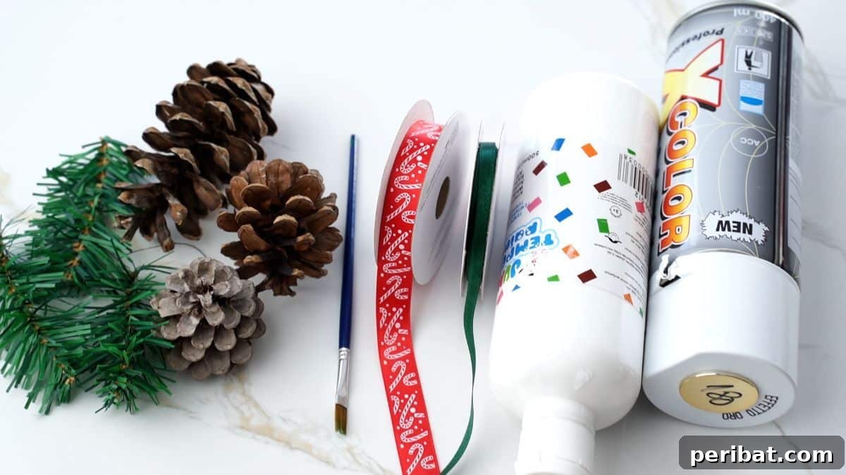 DIY Pinecone Christmas Ornaments 4 Collection of craft supplies including pinecones, paint bottles, ribbons, and brushes laid out on a white table