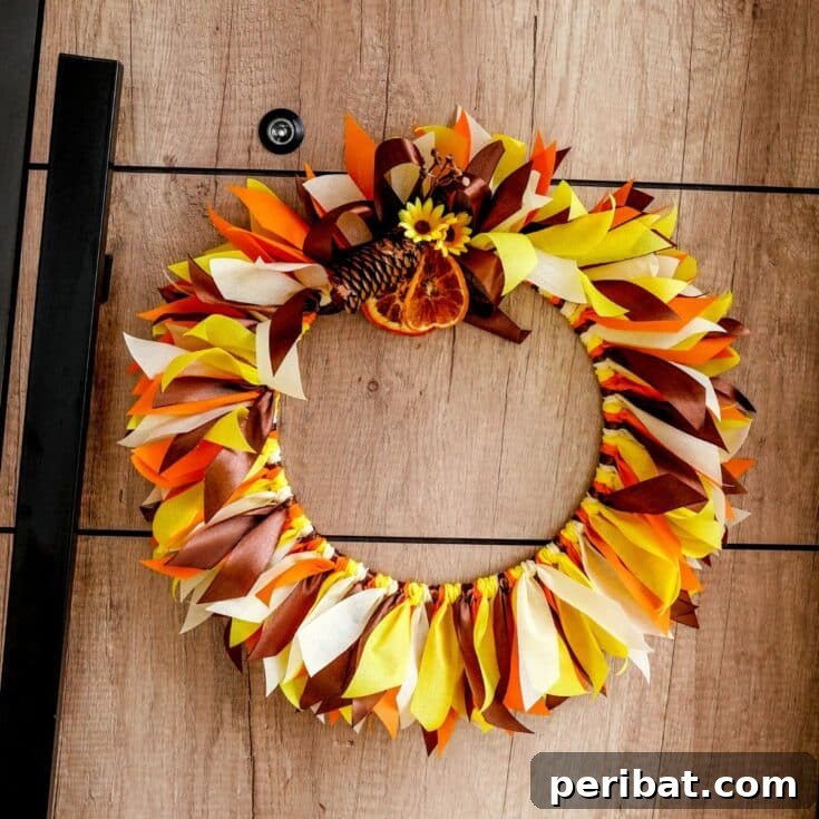 A charming rustic fall rag wreath hanging gracefully on a distressed wood wall, epitomizing cozy autumn farmhouse decor.