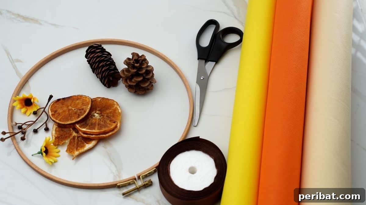 Autumn Farmhouse Wreath from Upcycled Fabric Scraps 4 Various craft supplies, including an embroidery hoop, fabric rolls, and pinecones, laid out on a table for making a fall wreath.