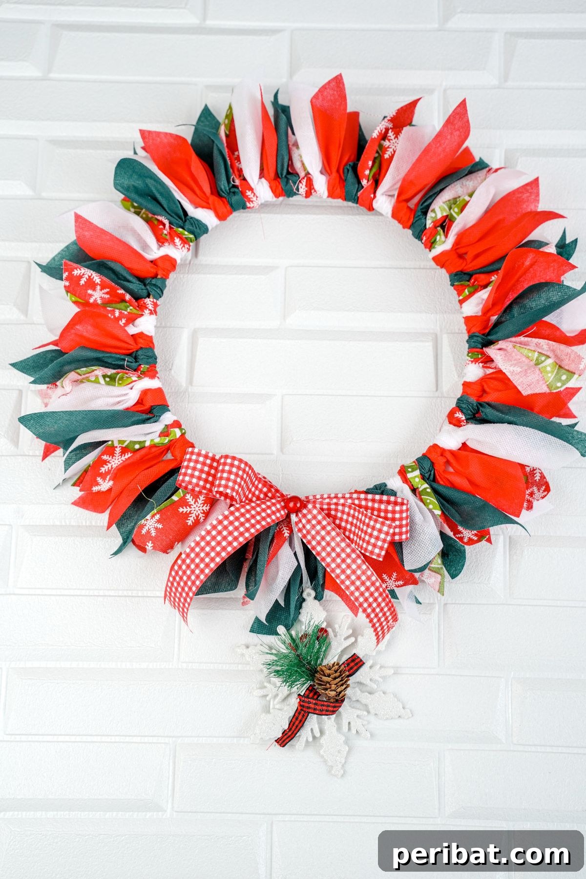 Effortless Festive Fabric Wreath 12 A beautifully completed Christmas rag wreath, featuring a harmonious blend of red, green, and white fabrics, set against a clean white background.