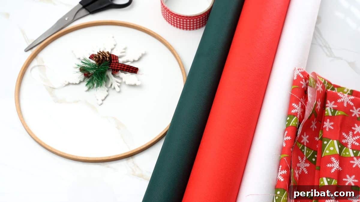 Effortless Festive Fabric Wreath 4 Rolls of red, white, and green Christmas themed fabric neatly arranged on a table next to holiday ribbon and a wooden embroidery hoop, ready for crafting.