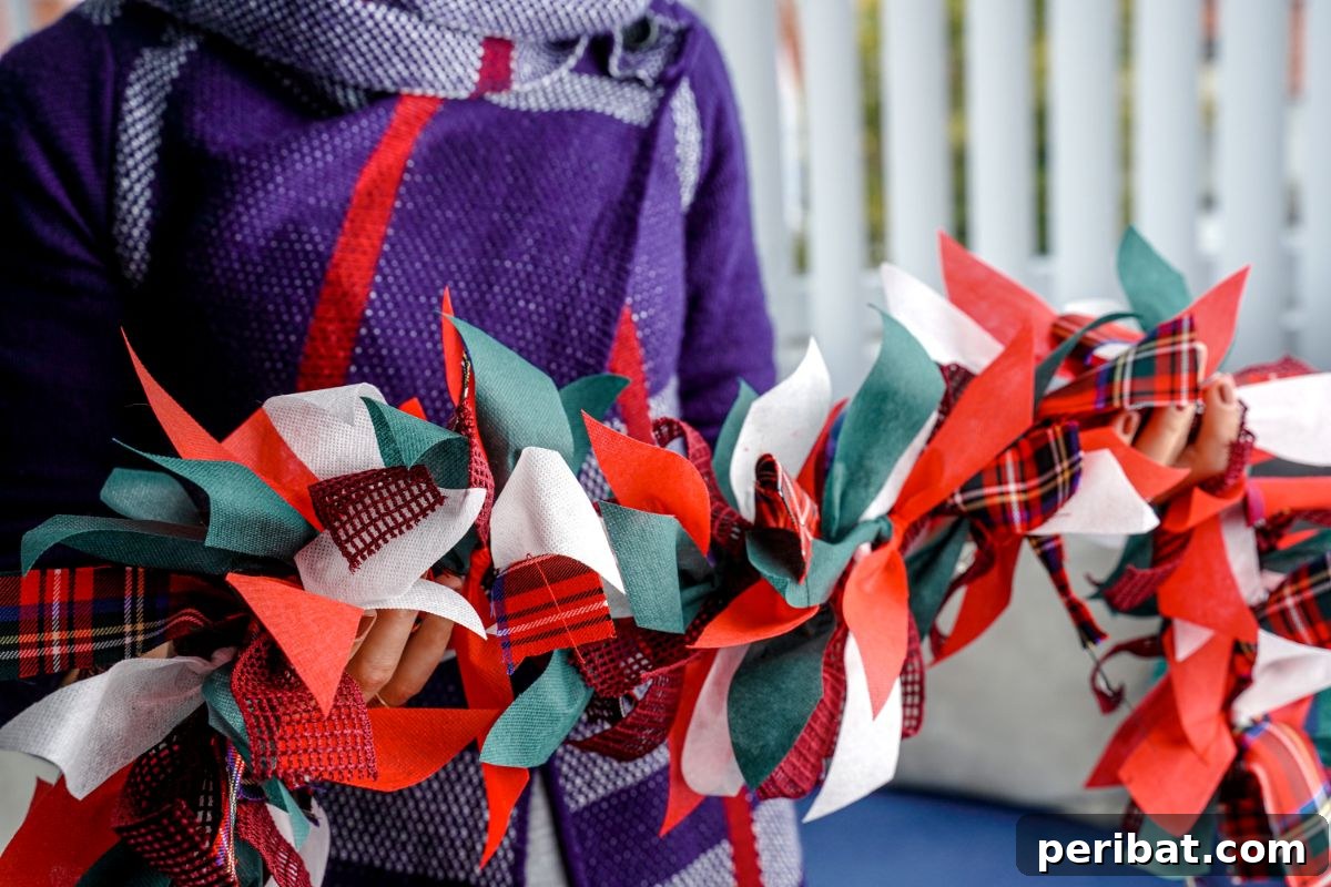 Handcrafted Rustic Christmas Rag Garland 13 woman in purple sweater holding a Christmas rag garland