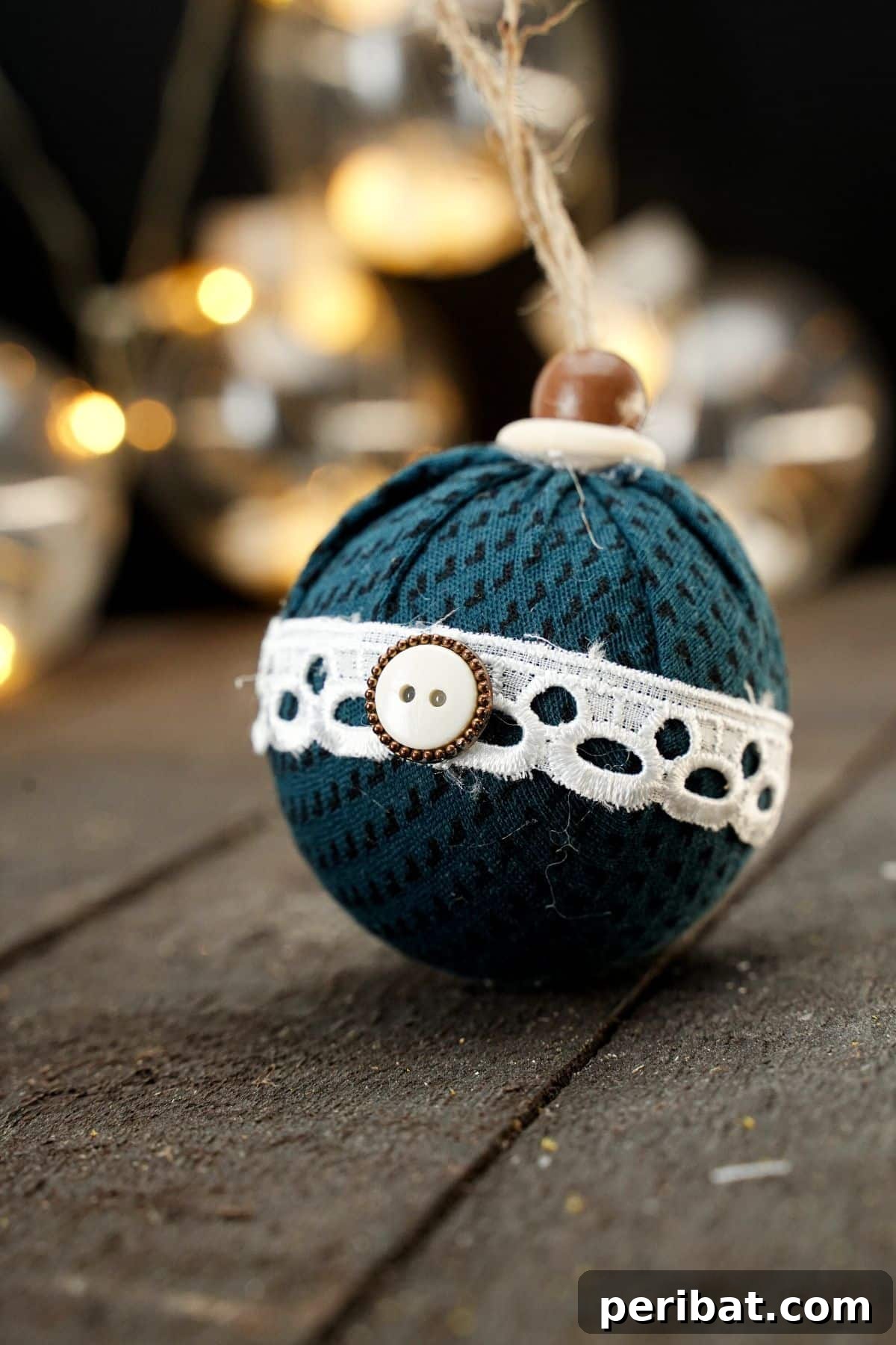 Chic Fabric Holiday Bauble 22 fabric ball ornament on wood table with lights in background