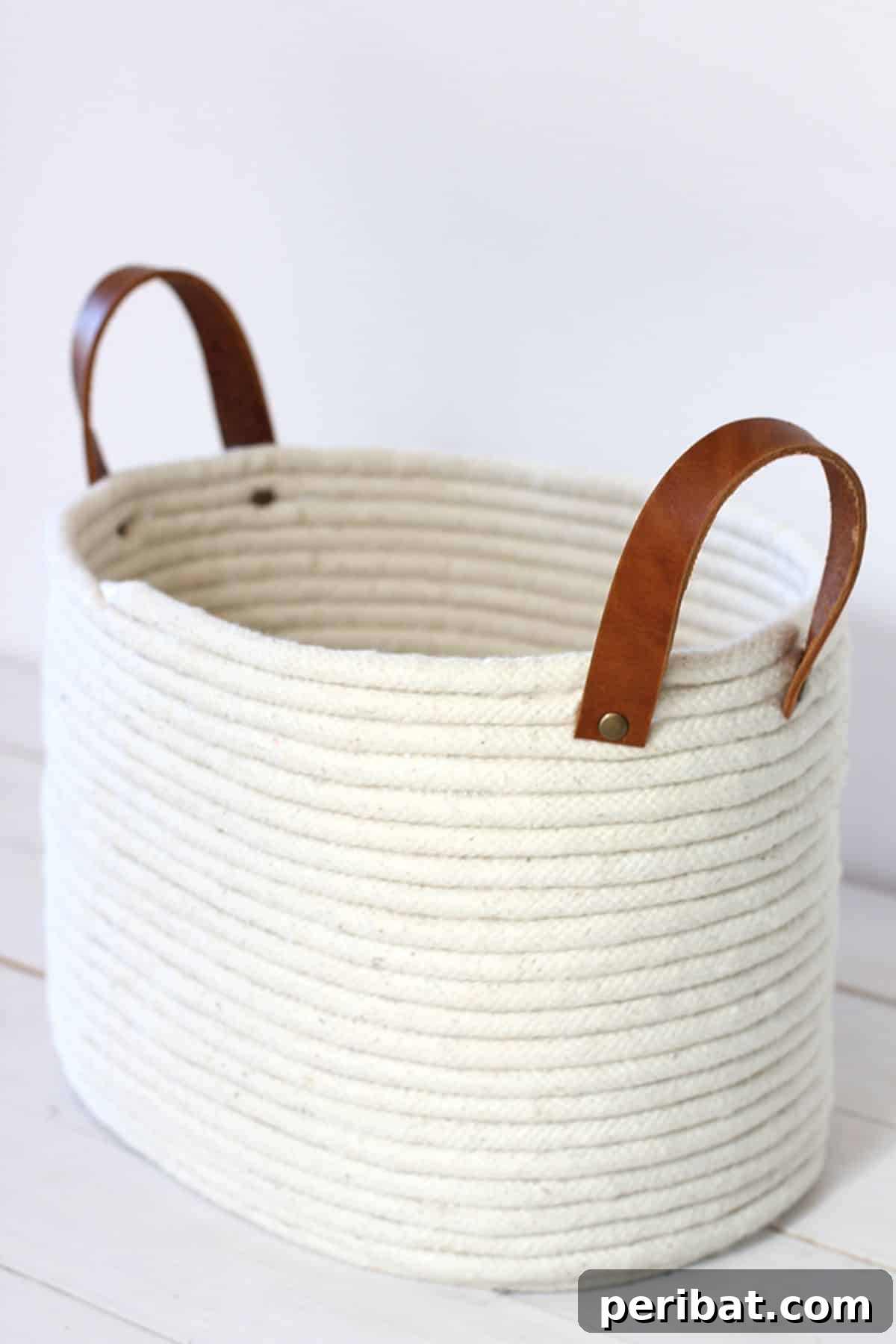 120 Inspiring DIY Boho Decor Ideas and Projects 123 Sturdy DIY no-sew rope coil basket with leather handles, perfect for knitting projects or stuffed animals, combining functionality with boho style.
