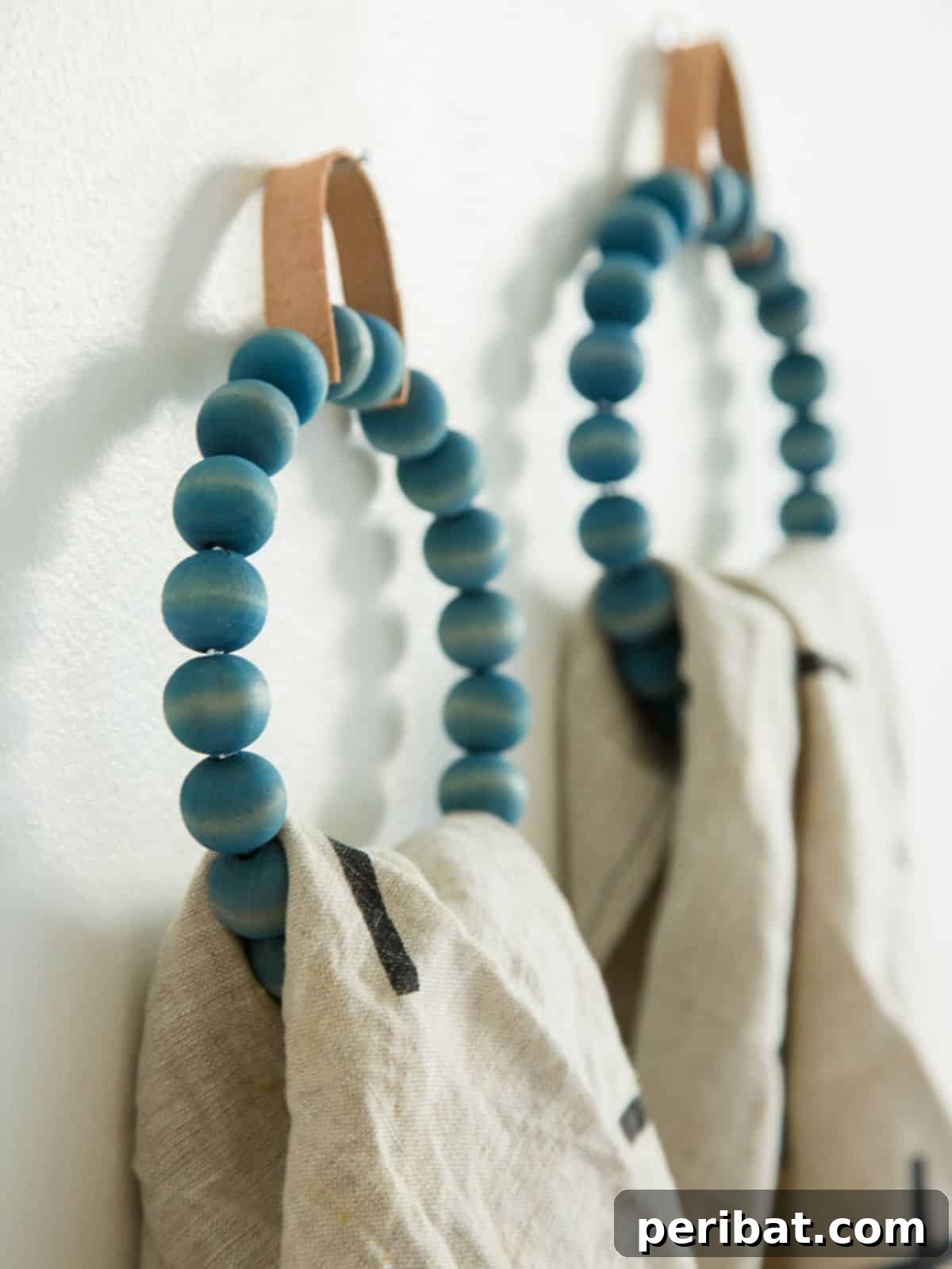 120 Inspiring DIY Boho Decor Ideas and Projects 91 Sophisticated DIY towel ring with wooden beads and dyed leather, upgrading bathroom aesthetics with a hand-crafted touch.