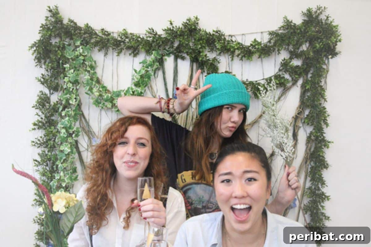 DIY photo booth backdrop using yarn, flowers, and fabric for party fun
