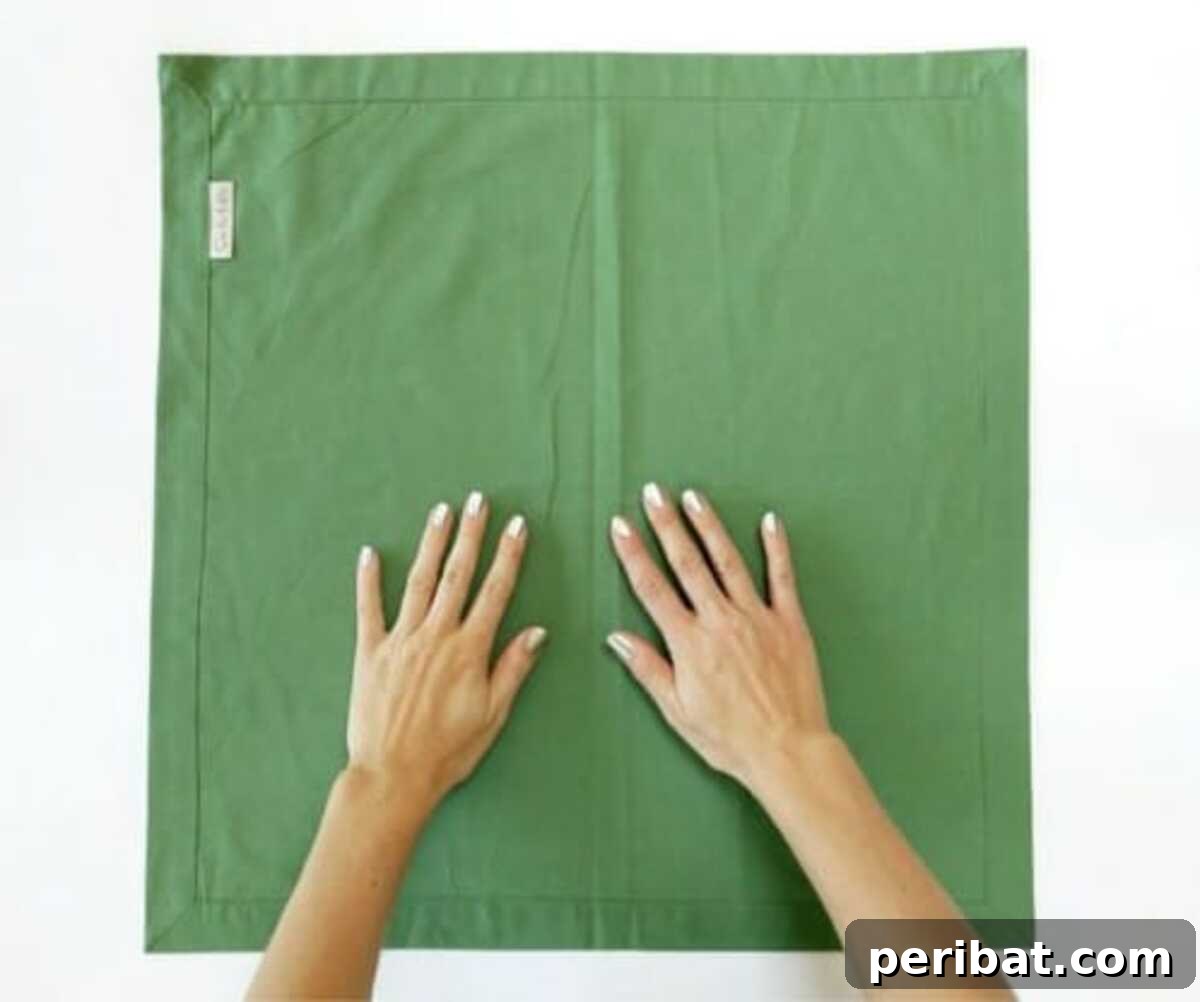 Deck Your Table: Napkins Transform into Christmas Trees 3 Amazing Folding Technique Turns Your Napkins into Christmas Trees - Step 1: Fold in half