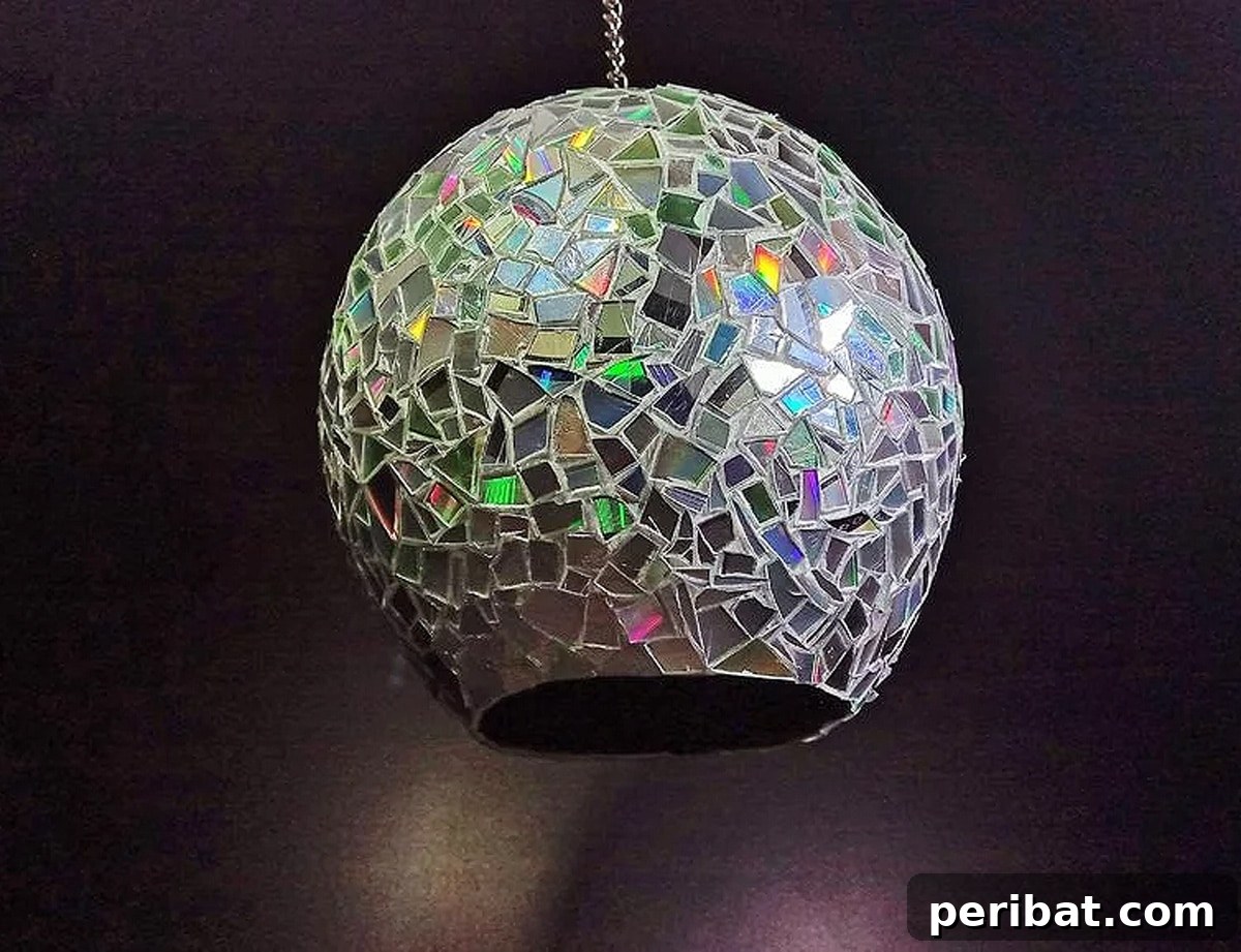 Unique mosaic lamp crafted with paper and CDs, a sustainable and inventive DIY project to add a personal touch to lighting.