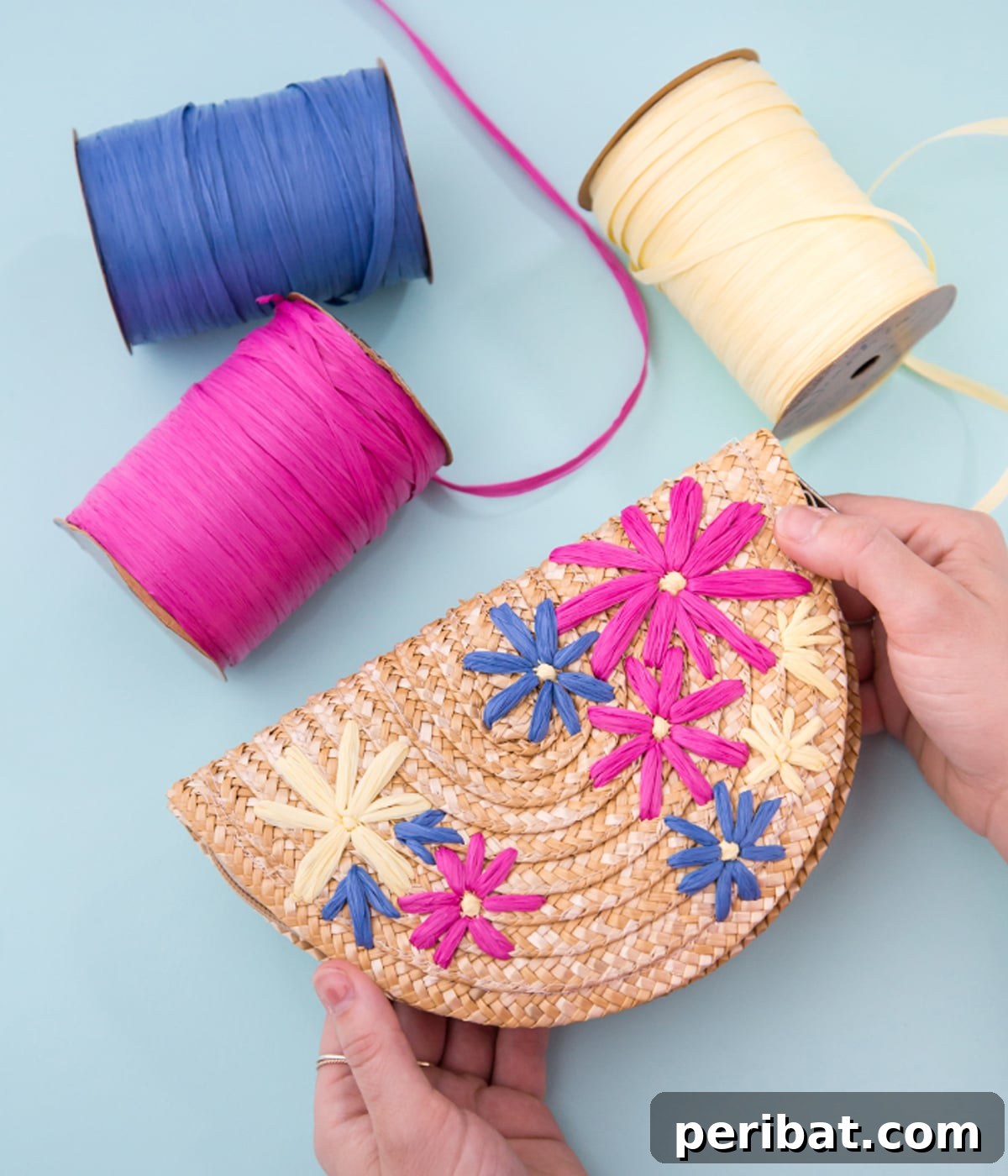 Creative DIY Floral Embroidery Ideas and Projects 16 Stylish DIY embroidered floral clutch next to three spools of raffia ribbon, ready for summer adventures