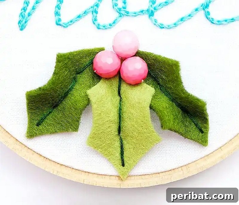 Stitch Your Way to a Merry Christmas: 48 DIY Embroidery Designs 19 A DIY Noel hoop ornament featuring embroidered leaves and beaded hats, embodying festive simplicity.