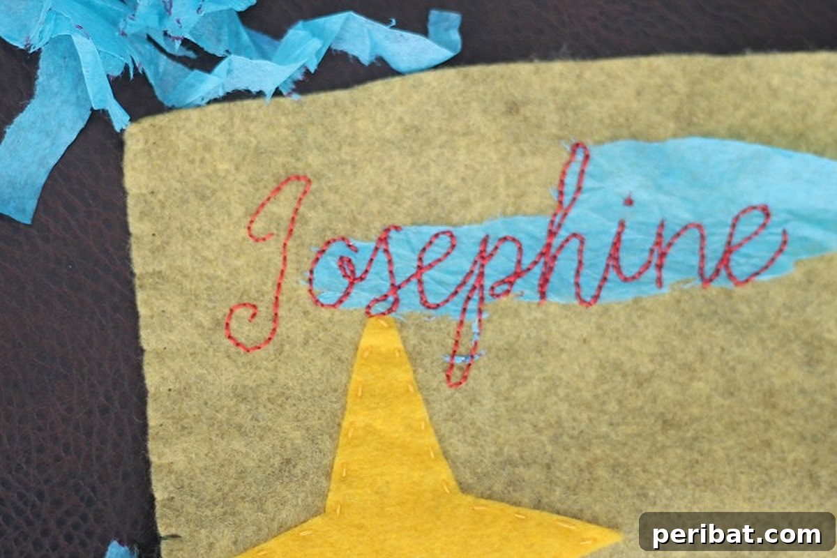 Stitch Your Way to a Merry Christmas: 48 DIY Embroidery Designs 33 A beautifully embroidered name on a Christmas stocking, adding a personalized touch.