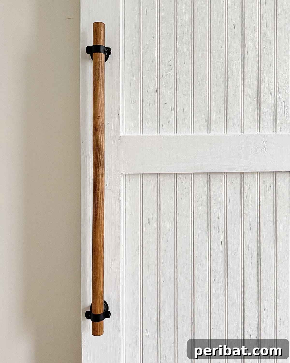 Clean and minimalist wooden barn door handle, spray-painted black for a modern look.