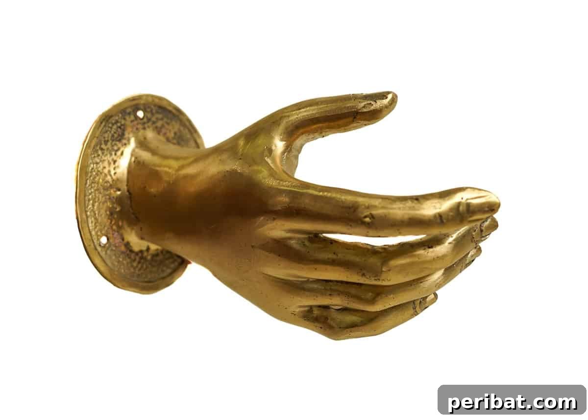 Unique pull brass hand-shaped door handle in a polished gold finish.