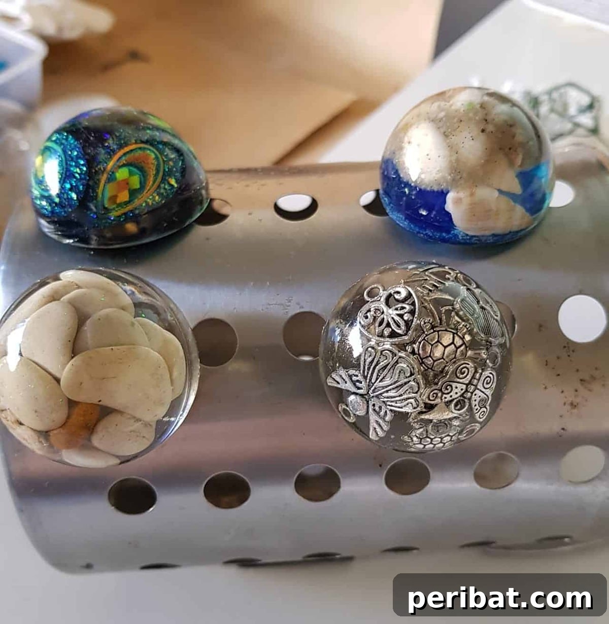 Four unique resin door knobs with embedded glitter and floral elements.