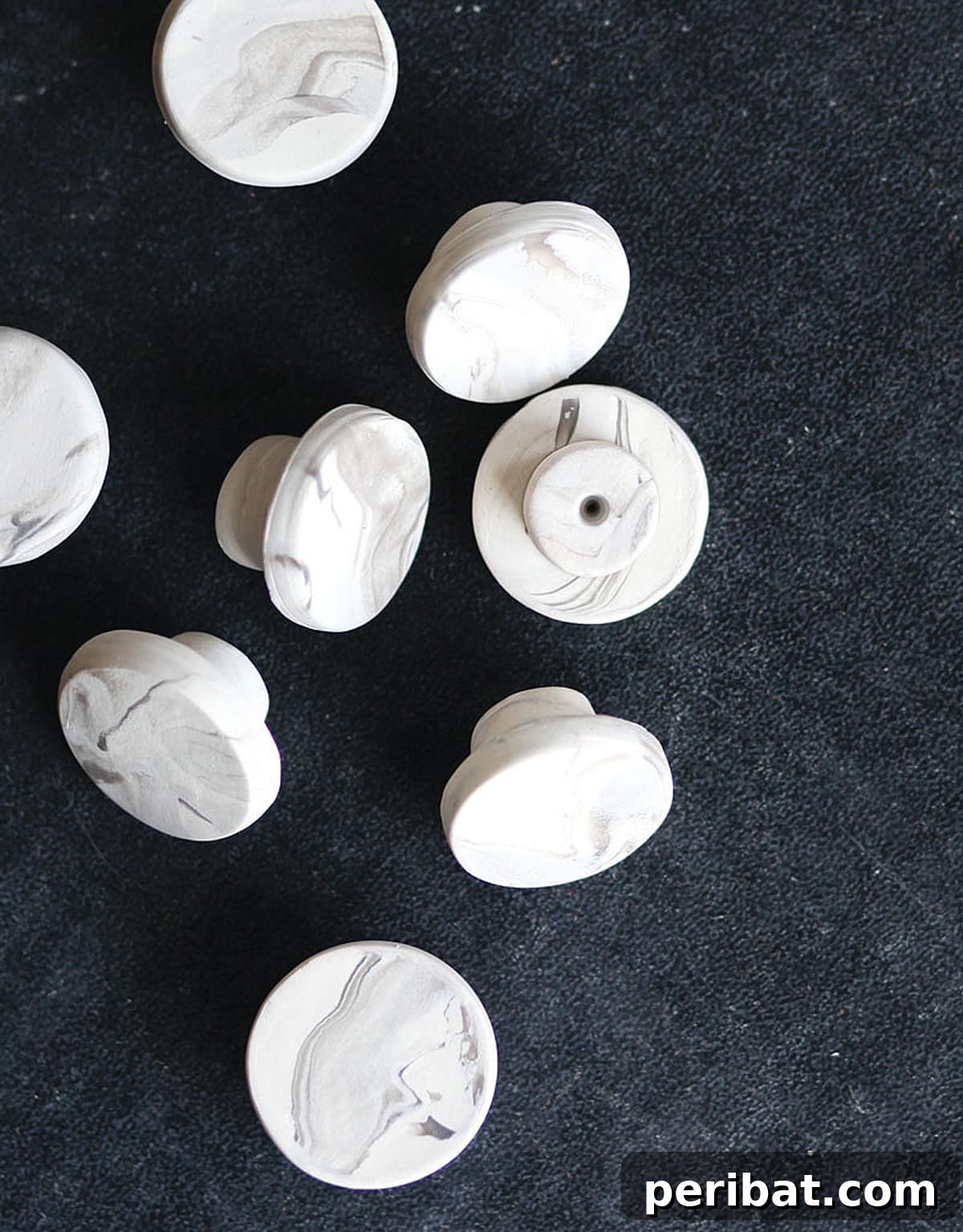 Eight elegant faux marble knobs, showcasing realistic veining and smooth finish.