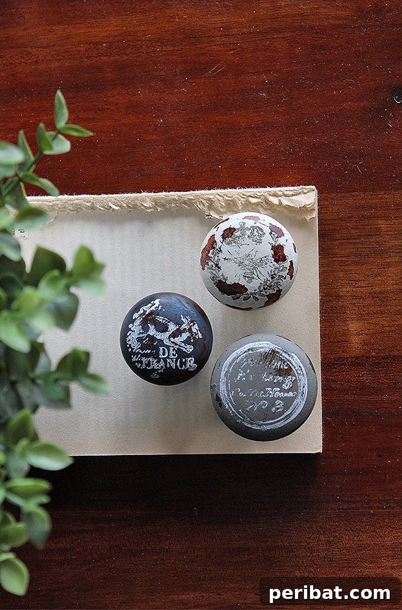 Three farmhouse stamped doorknobs on a table, featuring rustic text and patterns.