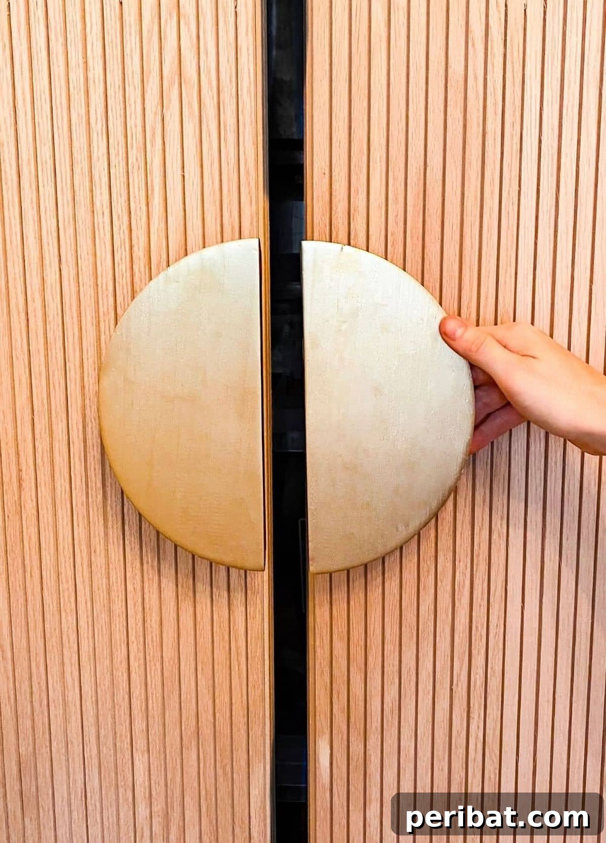 Sleek, modern half-moon handles in a metallic finish on minimalist cabinets.