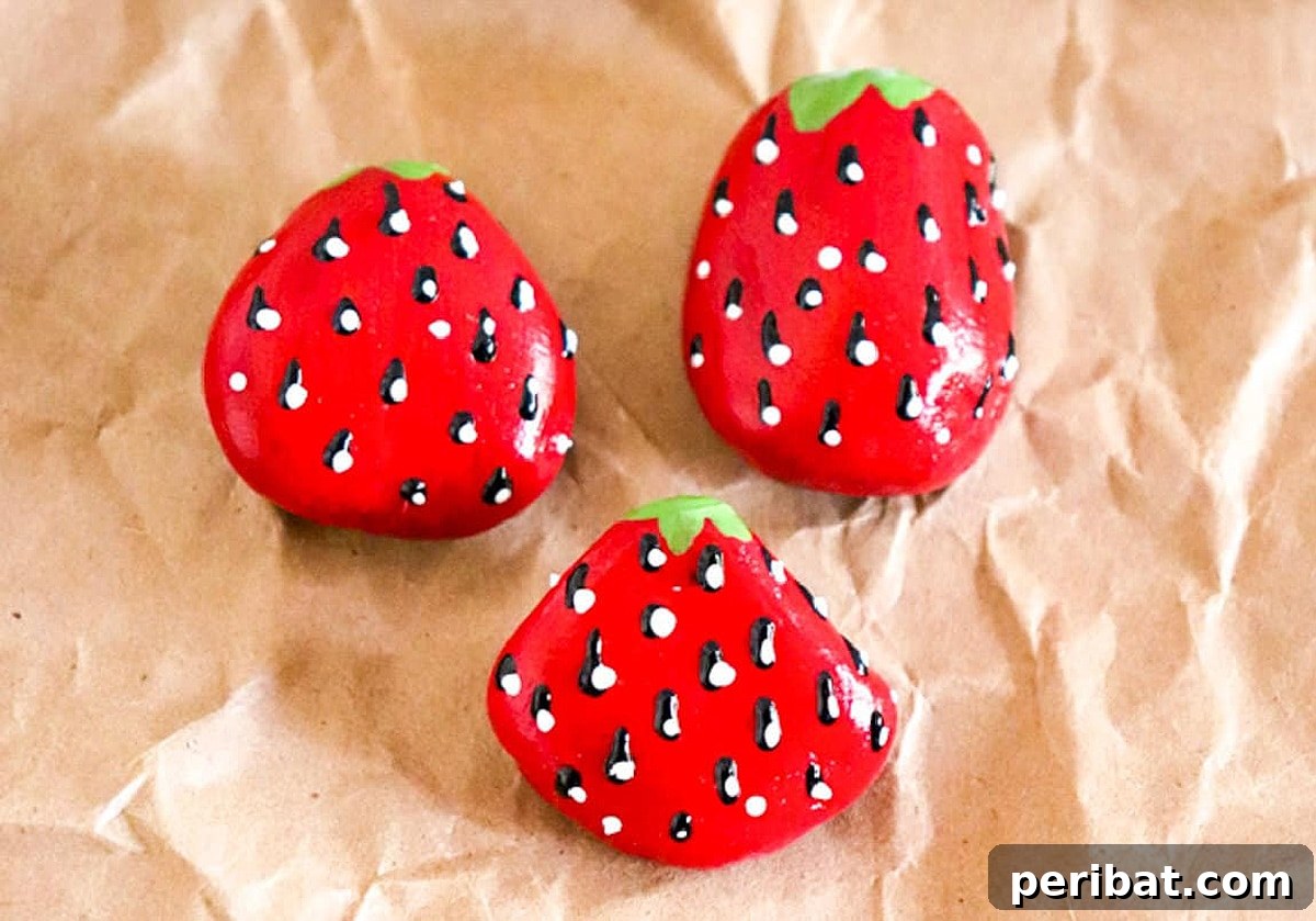 Creative Painted Rocks: Ideas, Projects, and Starter Kits 14 Vibrant red strawberry-painted rocks, looking juicy