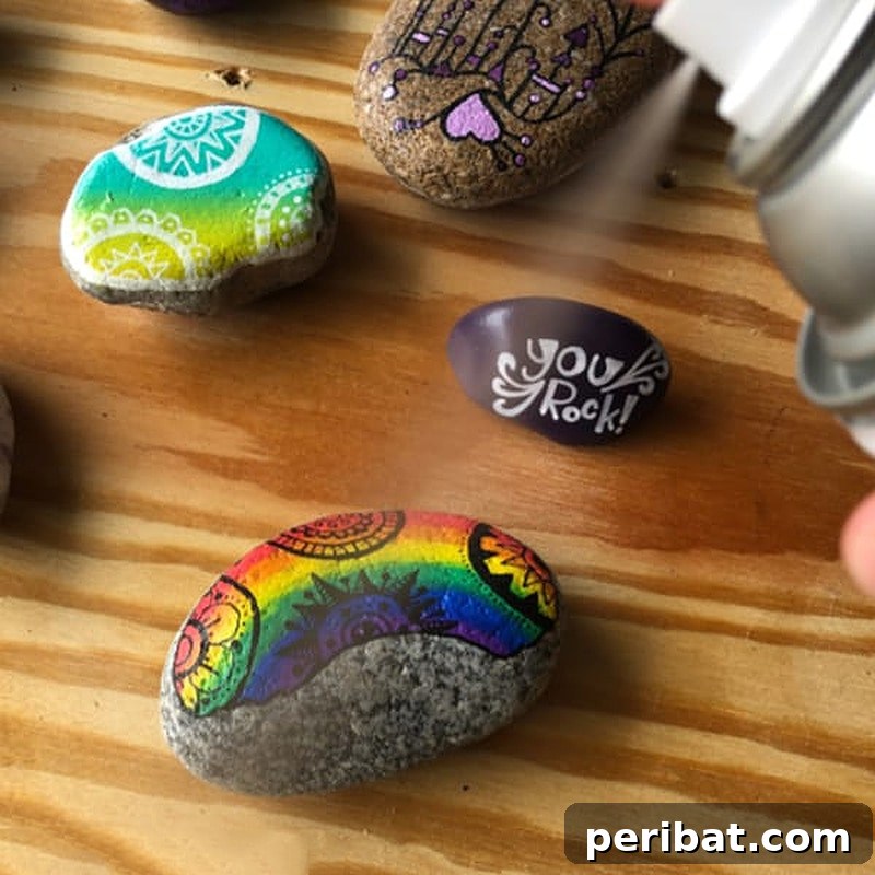 Creative Painted Rocks: Ideas, Projects, and Starter Kits 35 A painted stone with an uplifting message, being sprayed with gloss