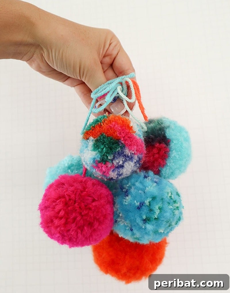 A close-up view of perfectly round, incredibly fluffy pom poms in various soft pastel colors.