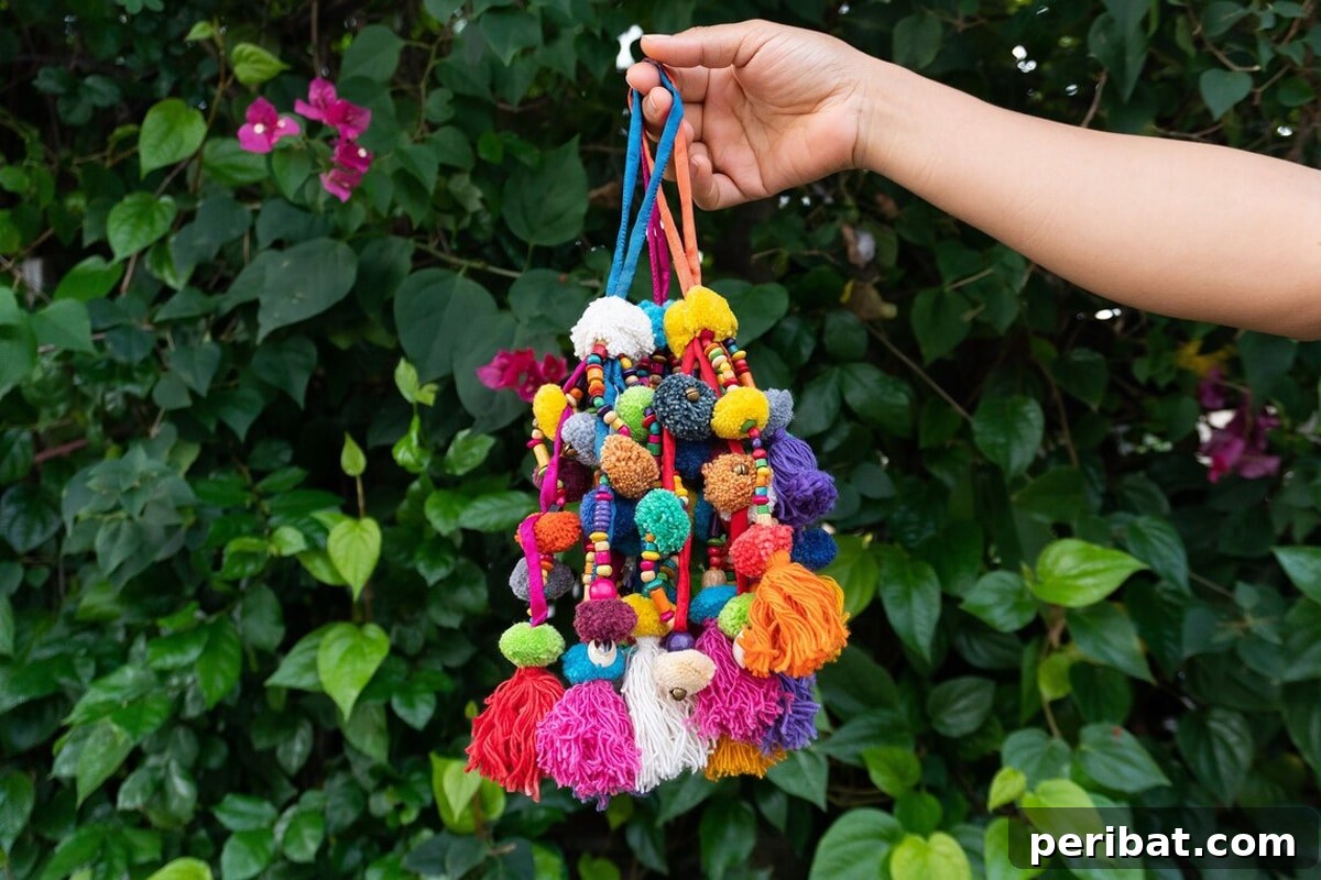 A vibrant, bohemian-style tassel featuring an assortment of colorful cotton pom poms and beads.