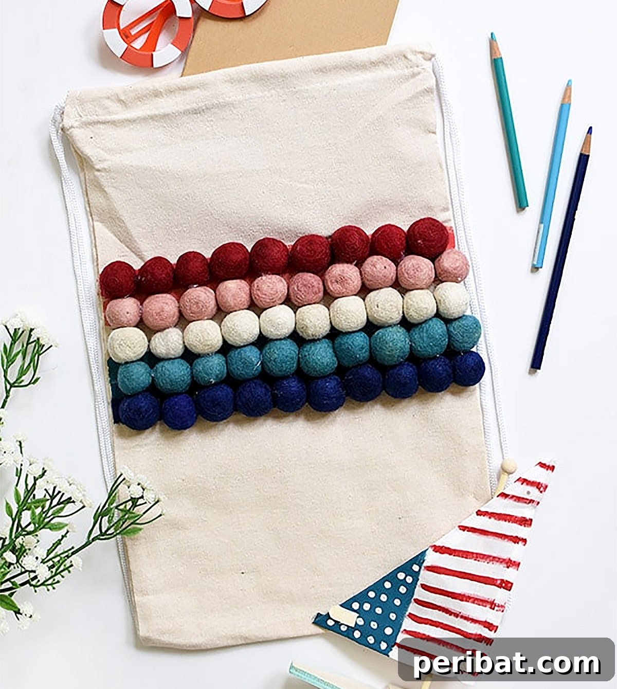 A stylish canvas tote bag adorned with a colorful array of pom poms, perfect for spring and summer.