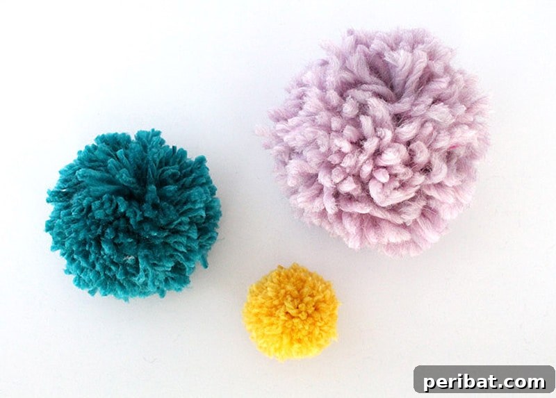 A collection of fluffy, vibrant pom poms of various sizes, showcasing the results of a cardboard maker technique.
