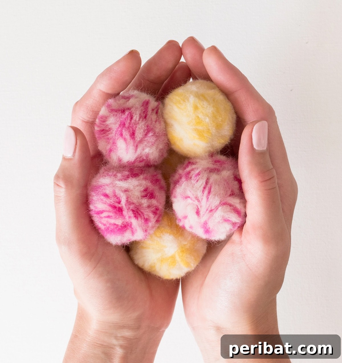 Beautifully textured marbled fluffy pom poms, featuring a blend of white, pink, and blue yarns.