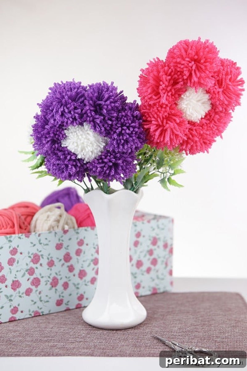 A charming arrangement of colorful yarn pom poms shaped like flowers, displayed in a small vase.