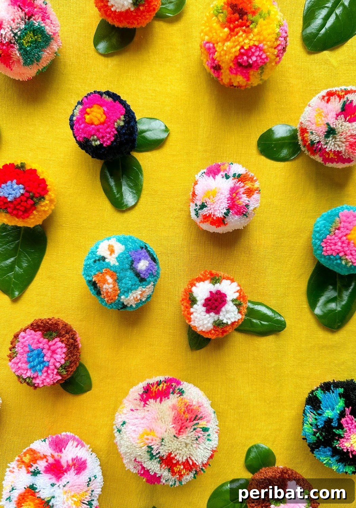 A close-up of patterned pom poms, including sprinkled, striped, and color-blocked designs.