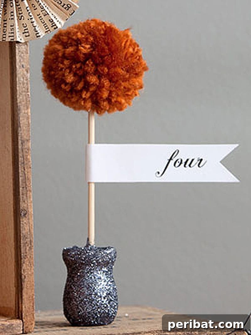 An adorable mini pom pom topiary in a small pot, made from green pom poms.