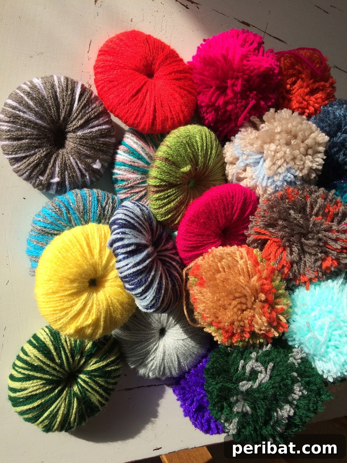 Step-by-step process showing how to make fluffy pom poms using wool yarn and cardboard templates.