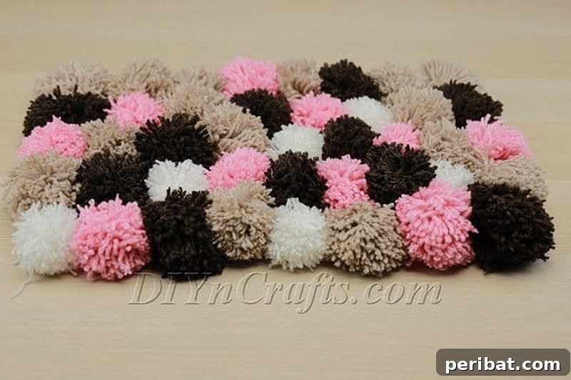 A plush, multicolored rug crafted entirely from numerous soft DIY pom poms.