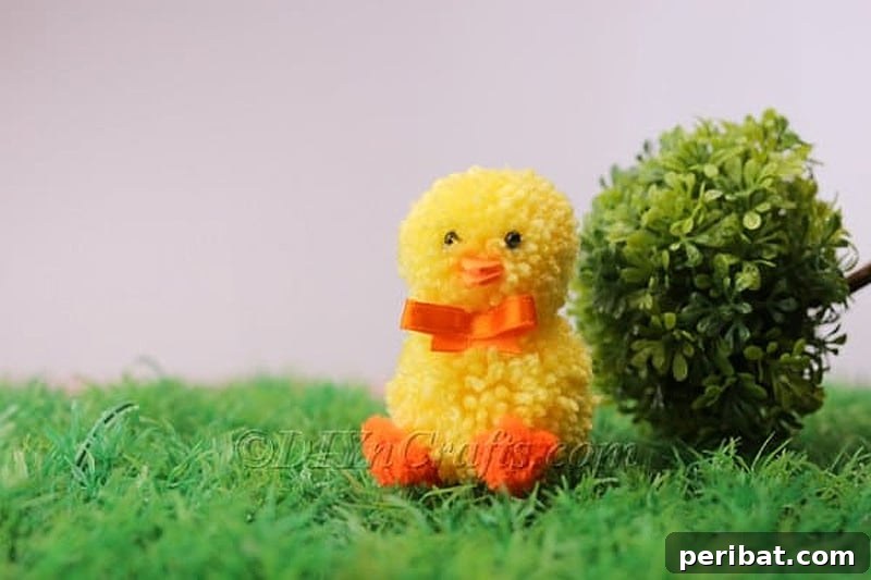 An adorable yellow pom pom chick with googly eyes and orange pipe cleaner feet, perfect for Easter decor.