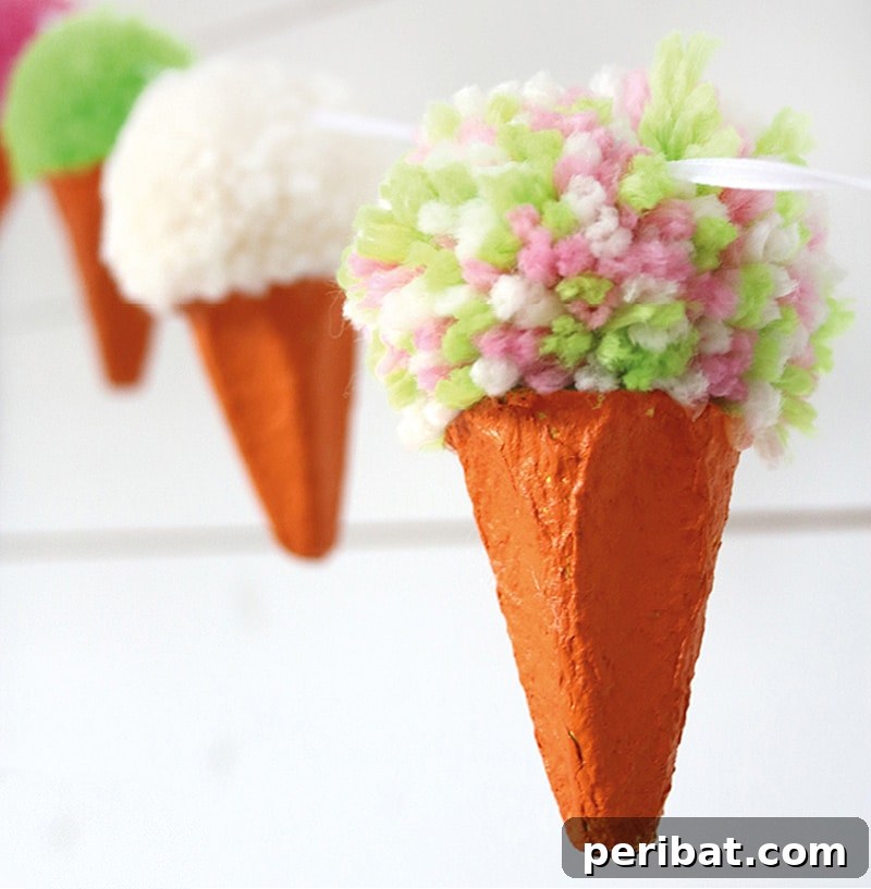 A charming DIY pom pom ice cream garland, with colorful yarn pom poms resembling scoops in paper cones.