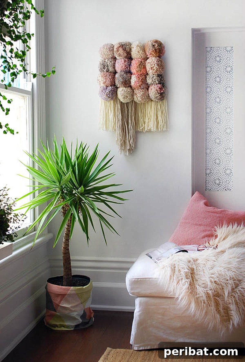 A trendy, bohemian-inspired pom pom wall hanging with various sized and colored pom poms.