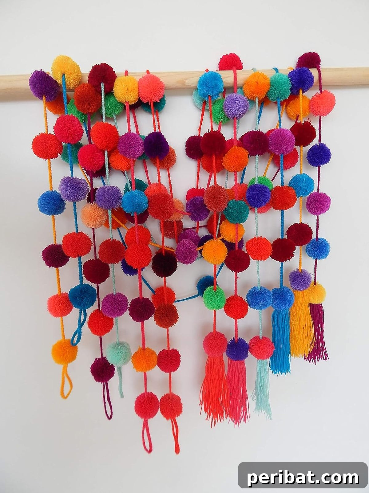 A vibrant, handmade Mexican fiesta pom pom garland, showcasing an array of bright, festive colors.