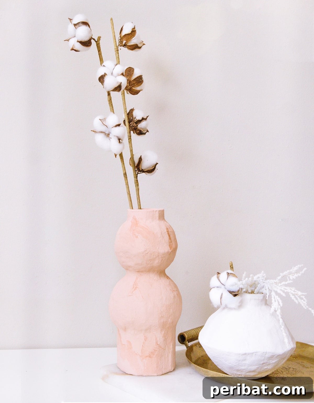 Modern, organic paper mache vases displaying dried flowers