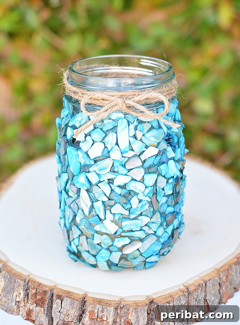 Coastal-themed DIY mason jar centerpiece with seashells and a flameless tea light