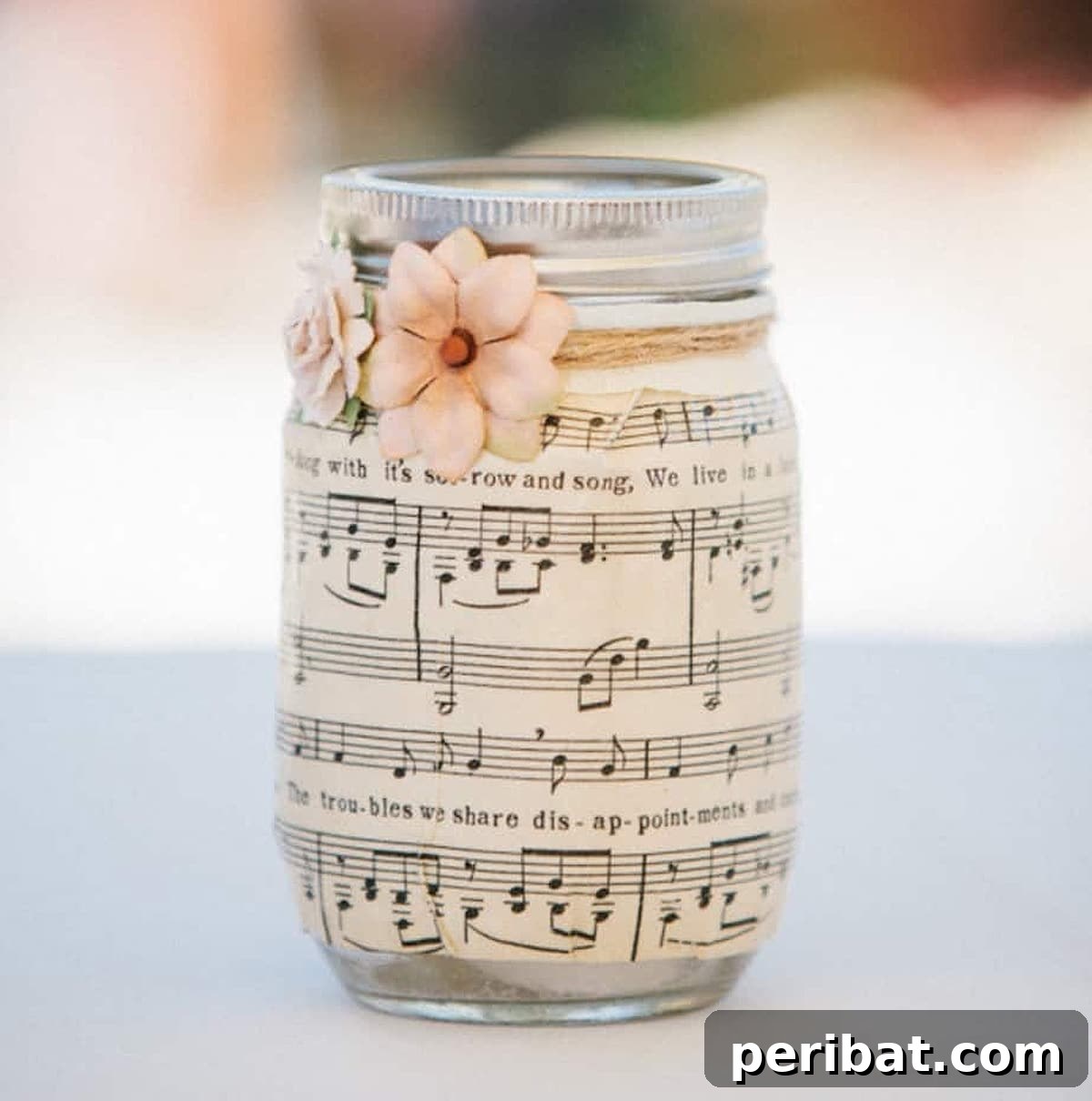 Unique sheet music mason jar centerpieces accented with twine and paper flowers