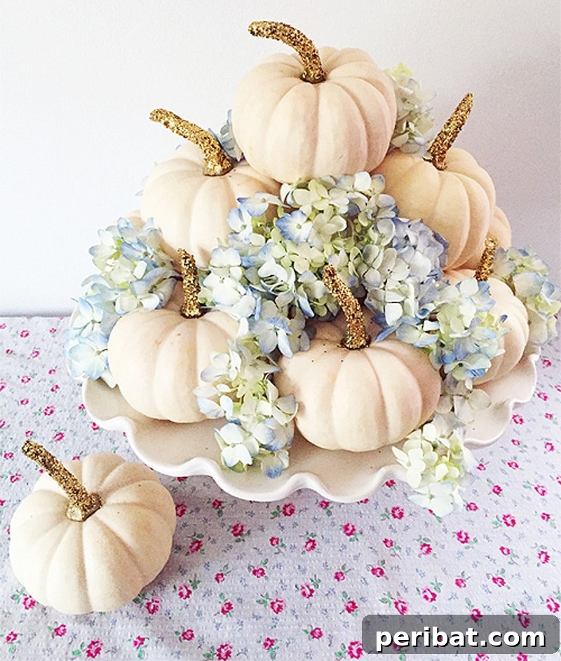 Radiant DIY centerpiece with gold-glitter mini pumpkins and fresh flowers