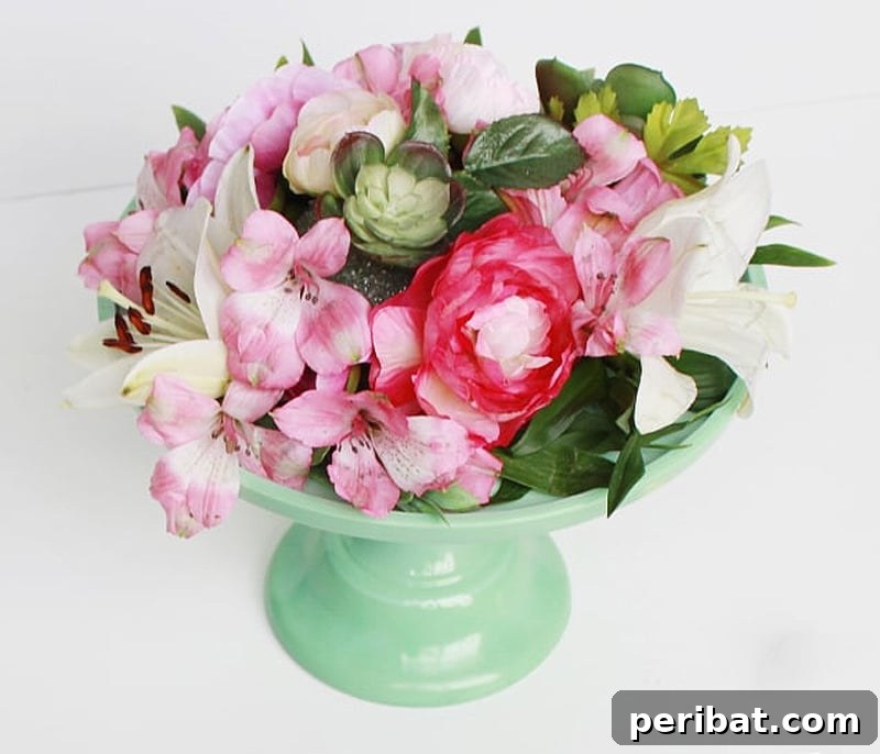 Stunning DIY floral arrangement atop an elegant cake stand centerpiece