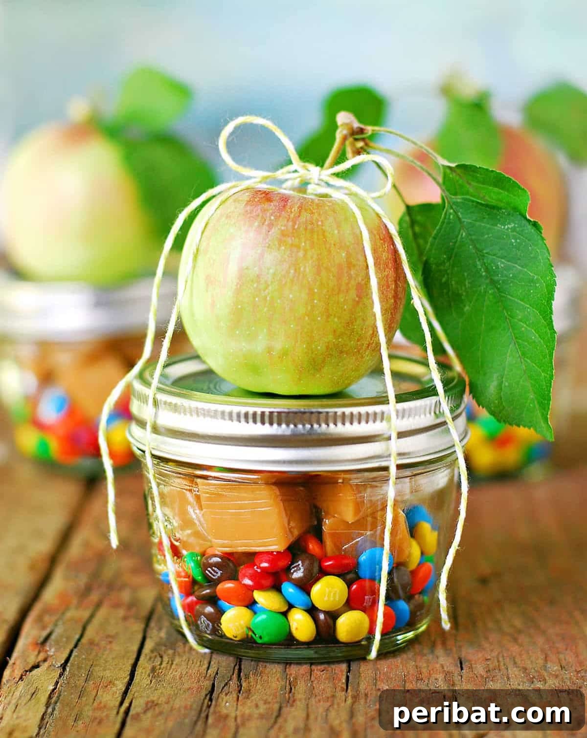 Delicious caramel apple in a jar, layered with caramel and mini M&Ms, a fun DIY party favor.
