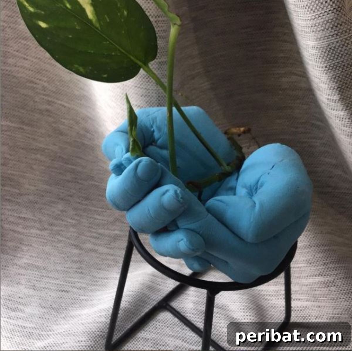 50 Smart DIY Home Improvement Hacks & Essential Products 3 Painted blue concrete hand planter, a unique hand-shaped pot holding a vibrant green plant, perfect for creative garden decor
