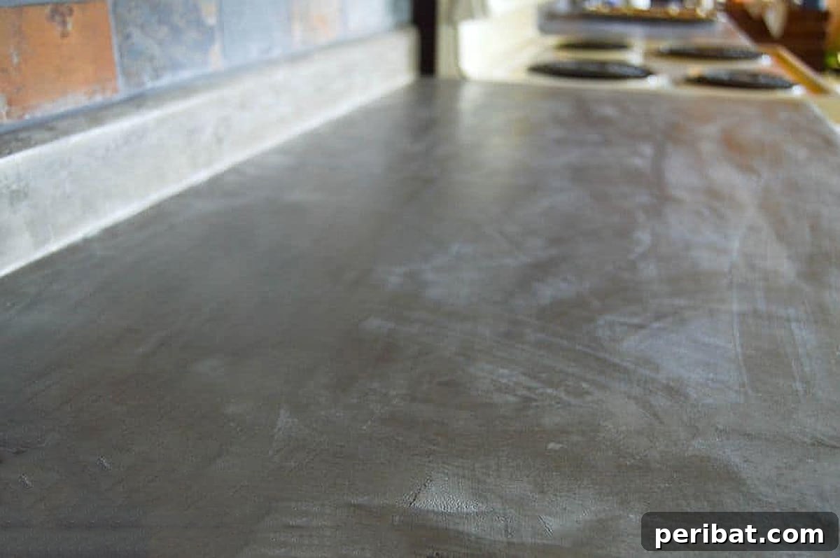 50 Smart DIY Home Improvement Hacks & Essential Products 43 Durable concrete countertops installed over existing laminate, showcasing a smart DIY upgrade for a modern and resilient kitchen