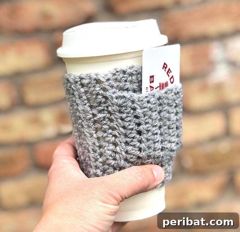 Knitted coffee cozy featuring a small, convenient pocket, perfect for holding a gift card