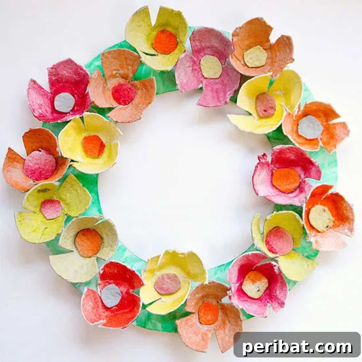 35 Mind-Blowing Creations from Empty Egg Cartons 14 A colorful and simple wreath made from painted egg carton flowers in various bright hues, perfect for a child's craft project.